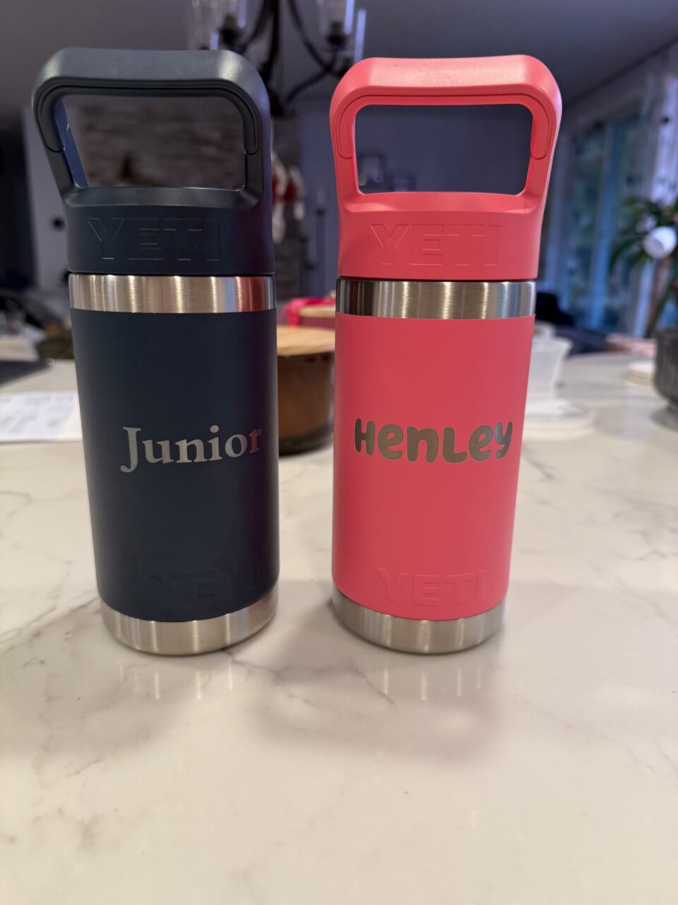 Navy and coral handled bottles engraved with the names Junior and Henley.