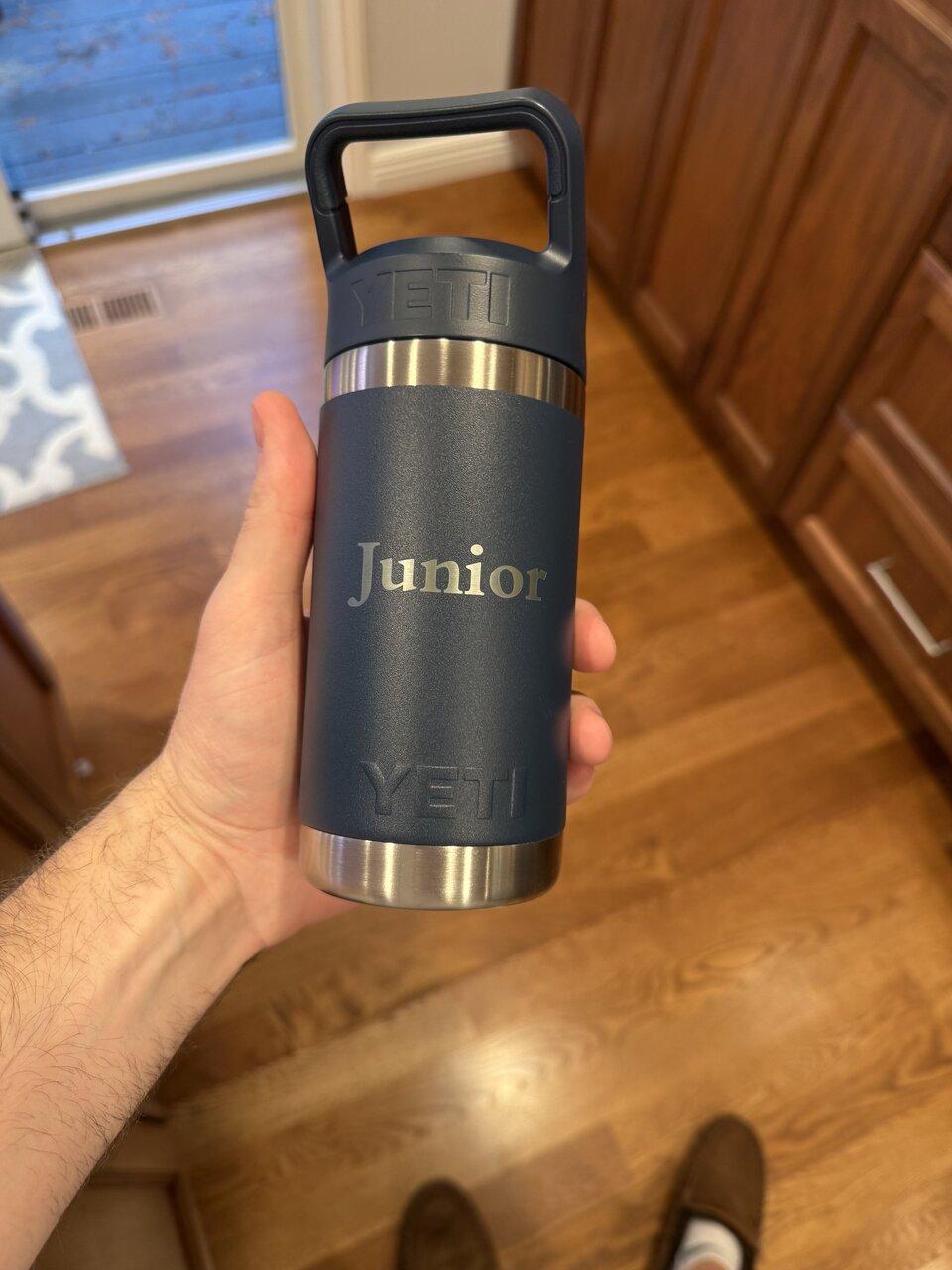 Close-up of a navy YETI bottle engraved with the name Junior.